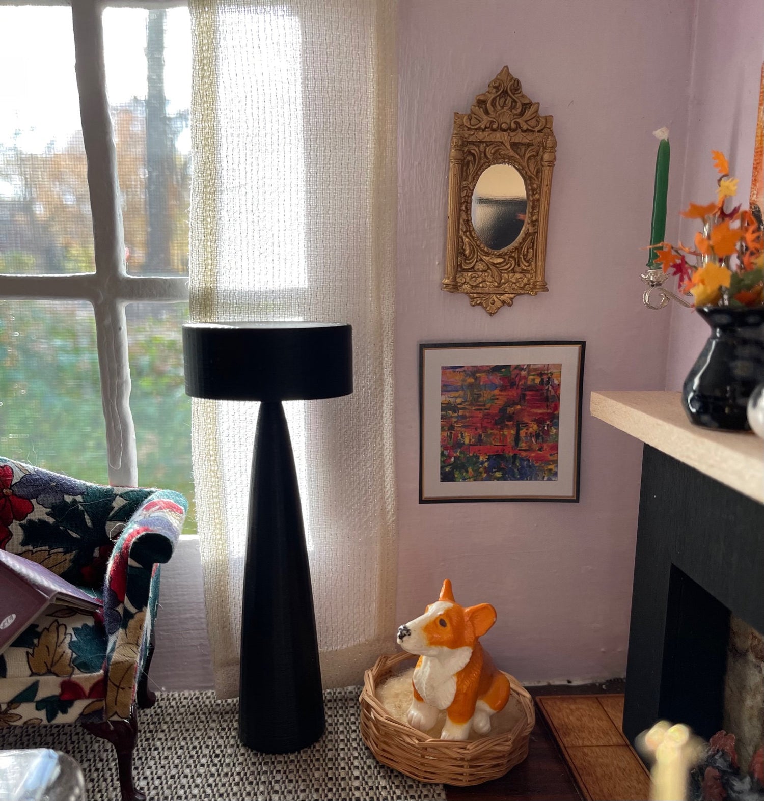 A miniature living room featuring an ornate gold mirror, a window with curtains, a lamp, and a small plastic dog in a wicker bed